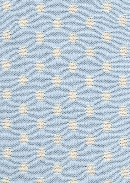 Patterned knit fabric with white dots on a light blue background