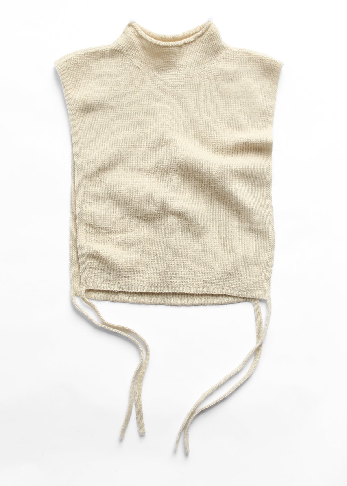 A cream-colored knit mock neck top with a sleeveless cut and drawstring ties at the waist, laid flat on a white background.