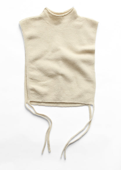 A cream-colored knit mock neck top with a sleeveless cut and drawstring ties at the waist, laid flat on a white background.