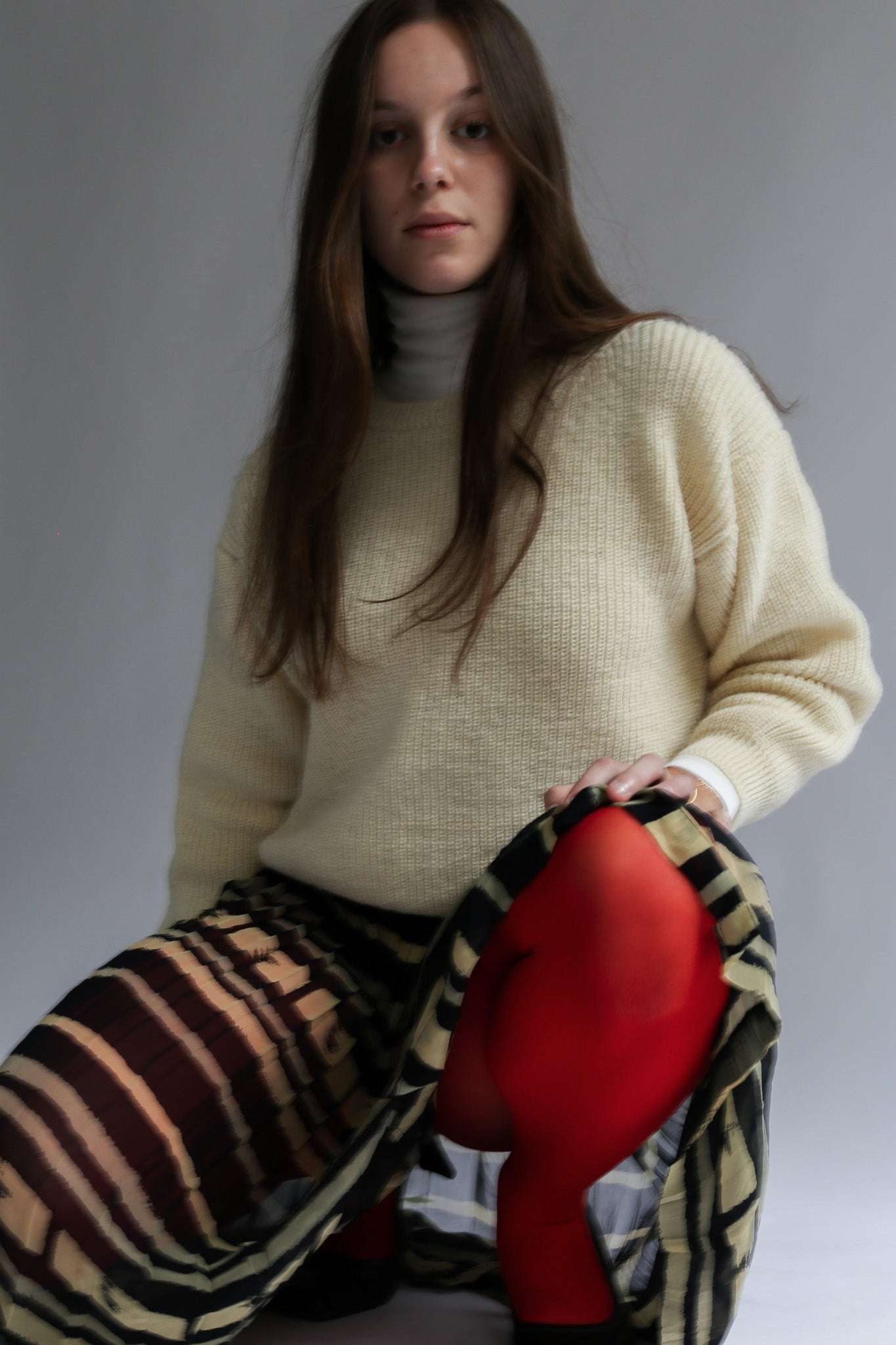 Woman wearing an off-white sweater handcrafted in Quebec from Canadian sheep wool (laine de beaurivage), studio shot, close-up