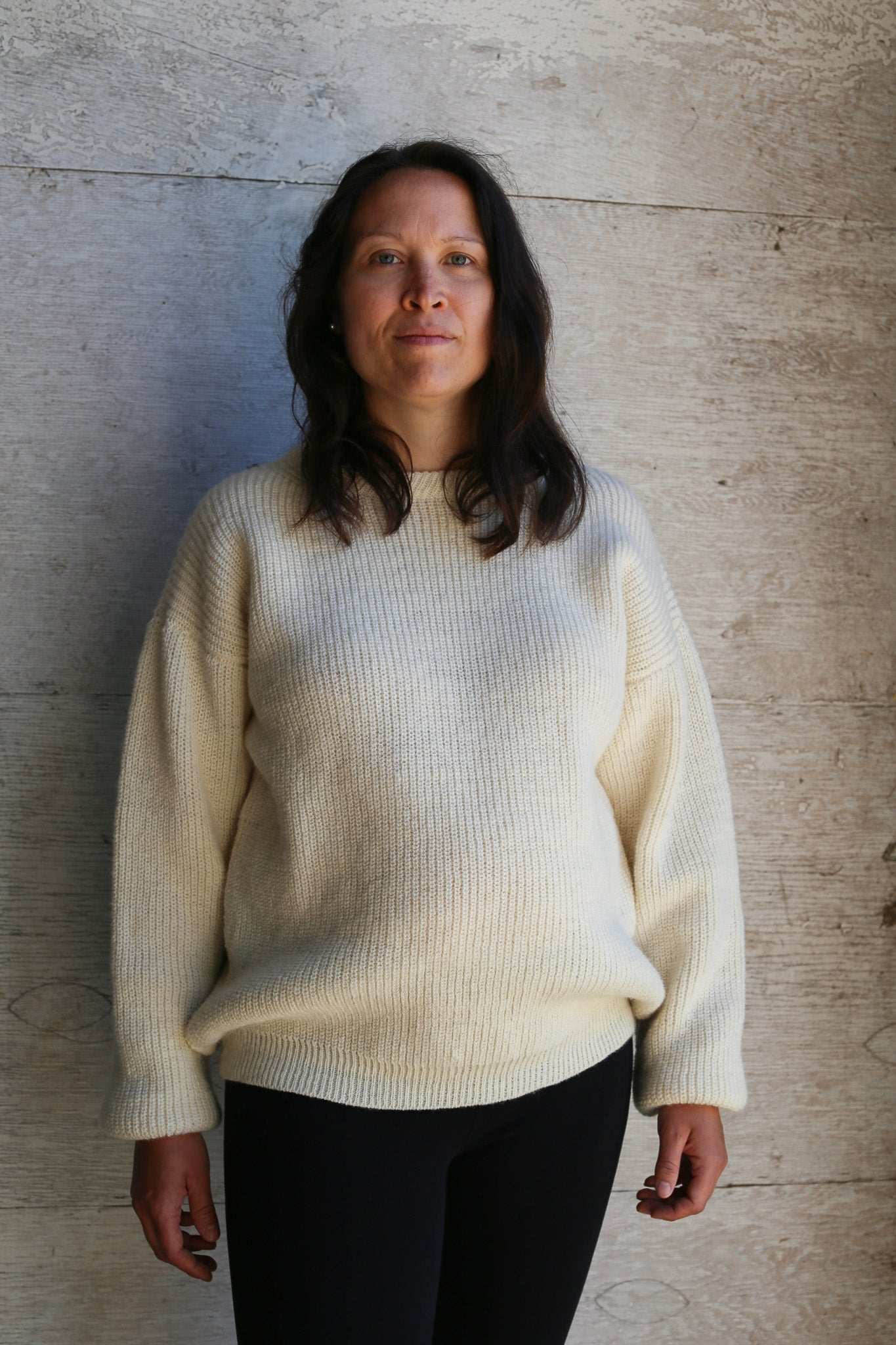 Woman wearing an off-white sweater handcrafted in Quebec from Canadian sheep wool (laine de beaurivage)