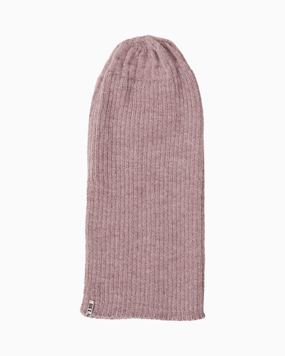 A ribbed alpaca knit beanie hat unrolled in a pink color, shown flat against a solid white background.