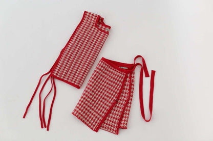 Red and white knitted houndtooth apron and skirt on a light gray background
