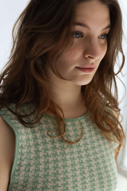 A woman wearing white and green houndstooth knit apron, close-up 