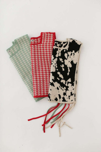 Three patterned tops in green and red houndstooth and animal pattern on a white background