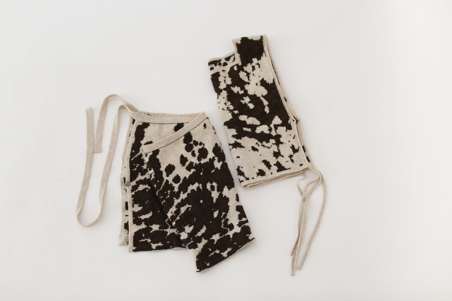Cow patterned knit skirt and apron top on a white background
