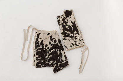 Cow patterned knit skirt and apron top on a white background