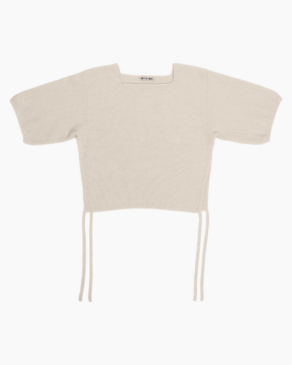 Beige belacaro baby alpaca knit top with short sleeves and drawcord ties, flat lay on white background.