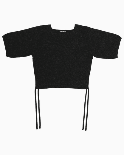 Black belacaro baby alpaca knit top with short sleeves and drawcord ties, flat lay on white background.