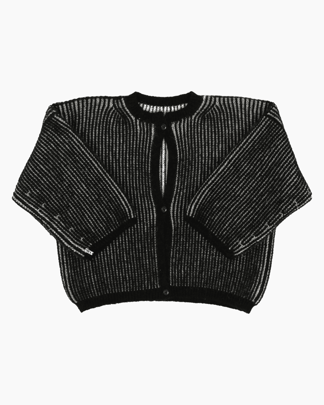 A bicolor white and black cardigan with a ribbed texture, 3 buttons down the front and wide 3/4 sleeves