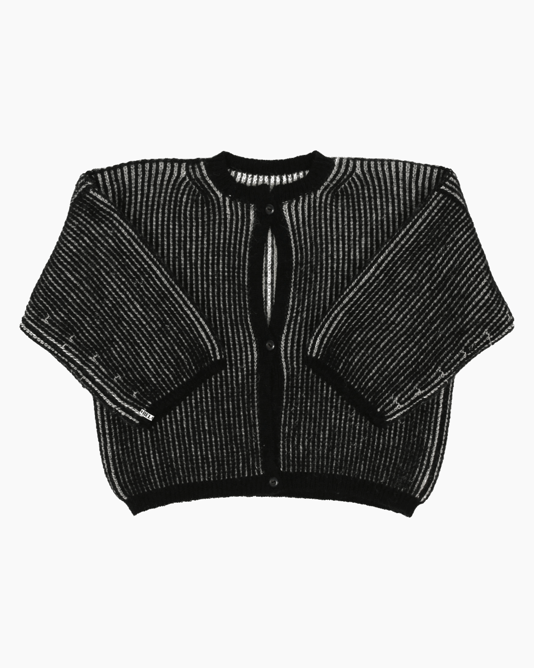 A bicolor white and black cardigan with a ribbed texture, 3 buttons down the front and wide 3/4 sleeves