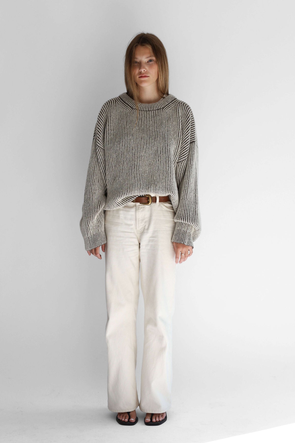 Model wearing a bicolor reversible crewneck sweater from the front against a white background