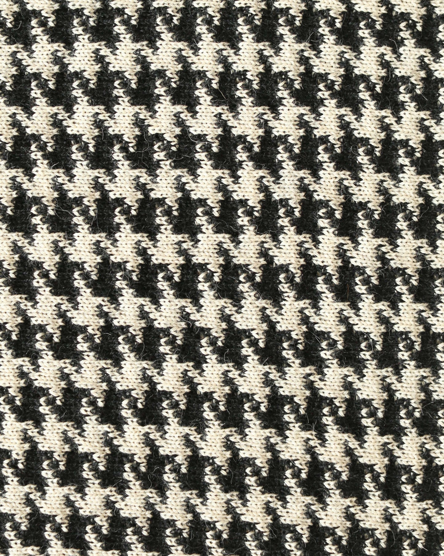 Close-up of a houndstooth patterned knit with black and white yarns.