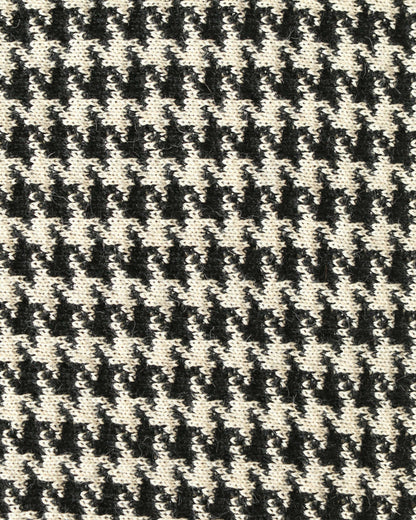 Close-up of a houndstooth patterned knit with black and white yarns.