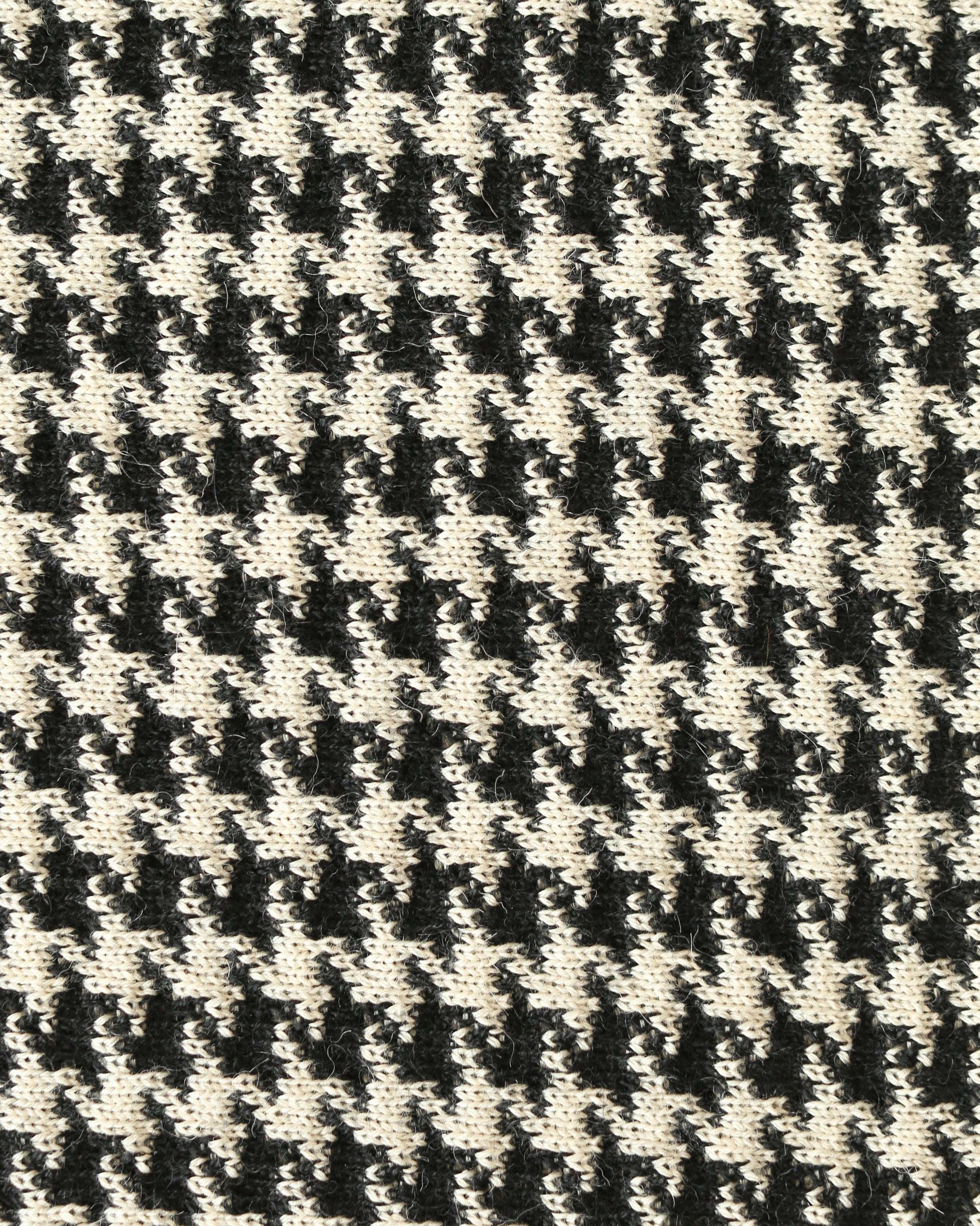 Close-up of a houndstooth patterned knit with black and white yarns.