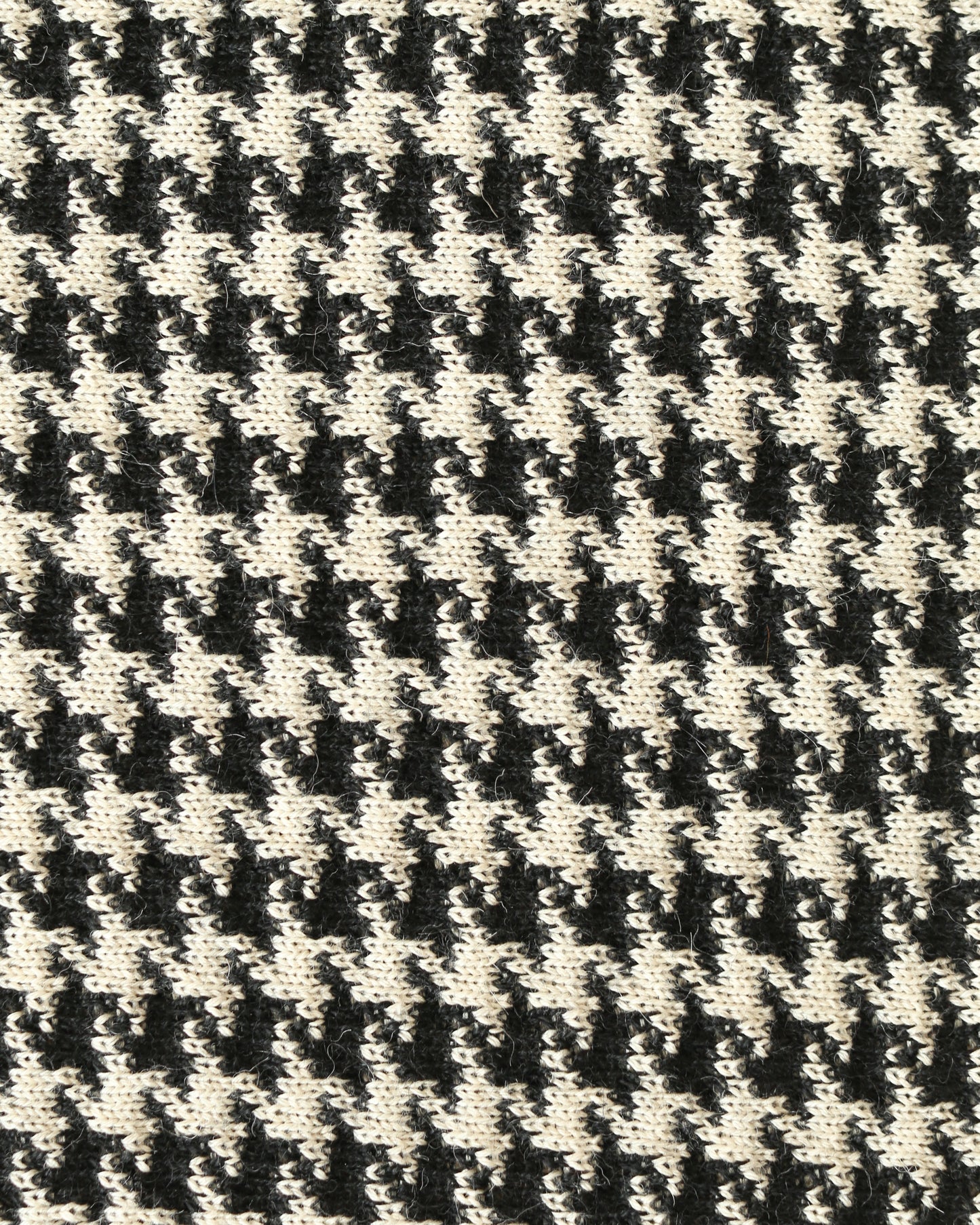 Close-up of a houndstooth patterned knit with black and white yarns.