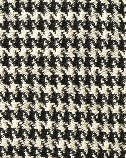 Close-up of a houndstooth patterned knit with black and white yarns.