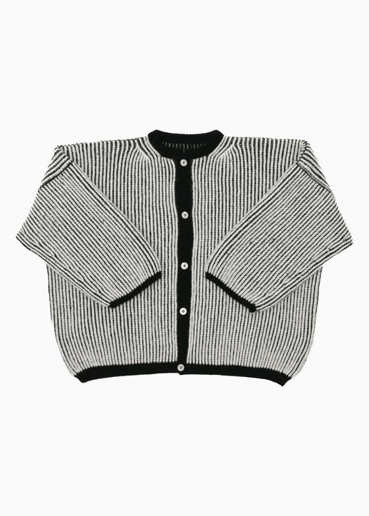 A bicolor black and white oversize cardigan with a ribbed texture, 3 buttons down the front bicolor oversized and wide 3/4 sleeves