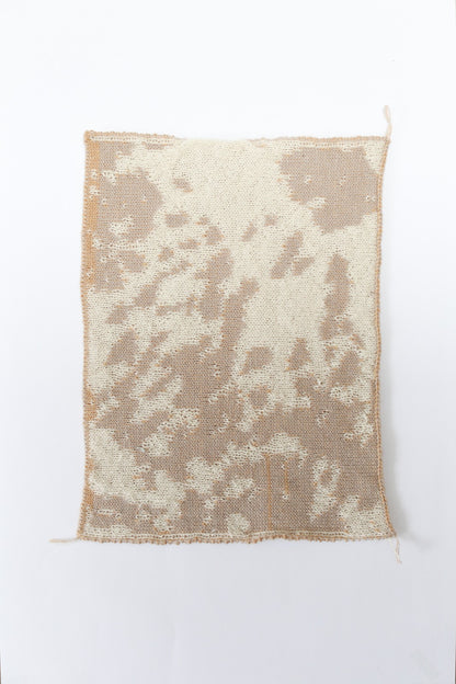 Cow patterned cream and tan knit swatch on a white background