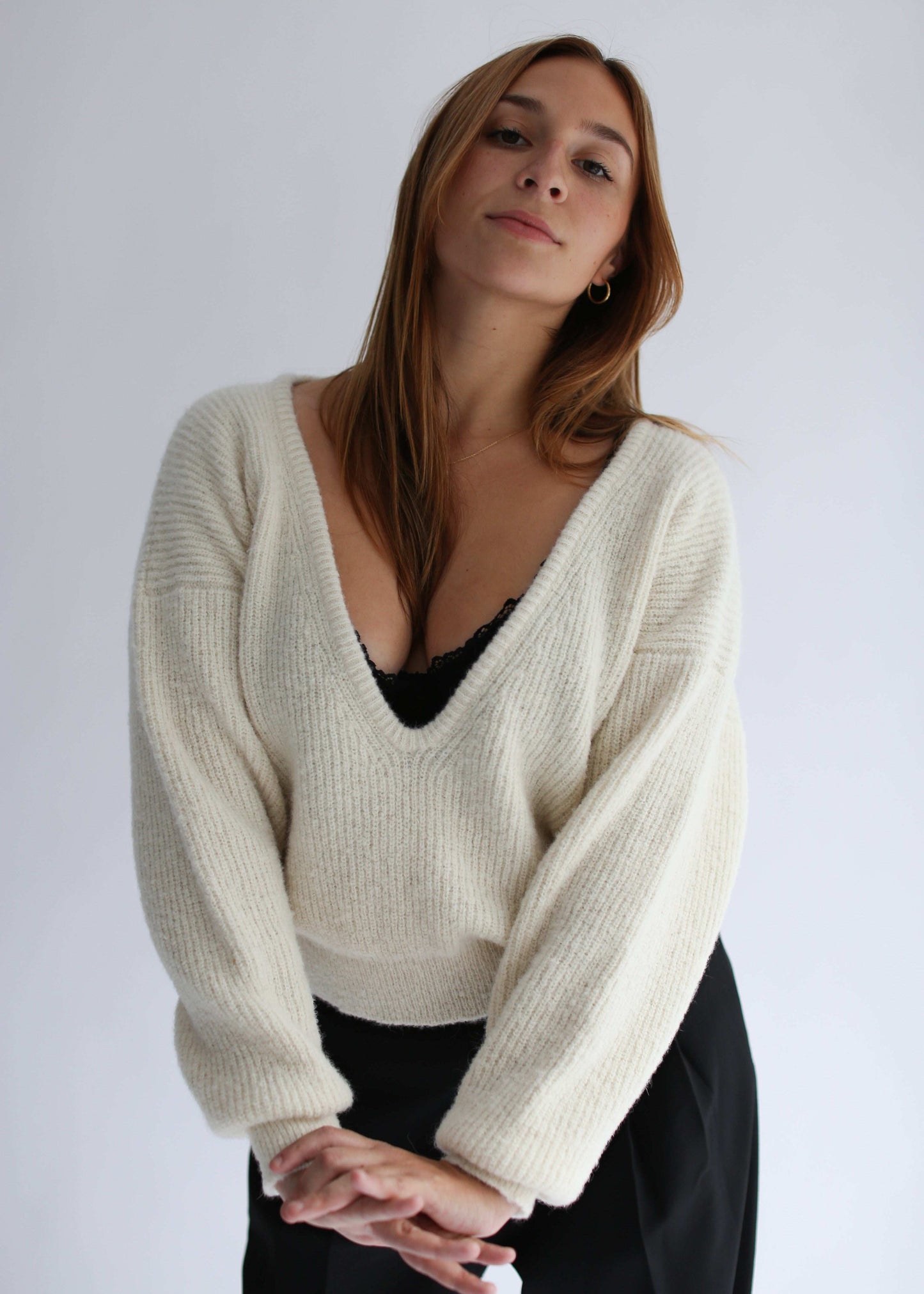 Woman wearing a white sweater with a deep v neck