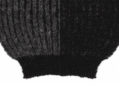 Sleeve detail of a grey and black ribbed knit 