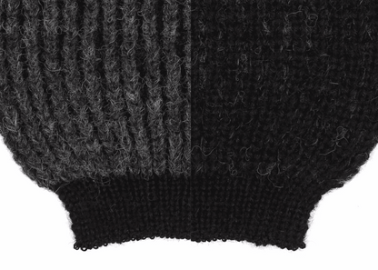 Sleeve detail of a grey and black ribbed knit 