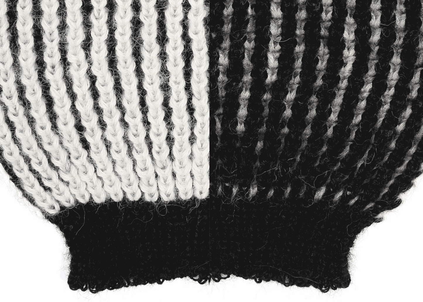 Sleeve detail of a white and black ribbed knit 