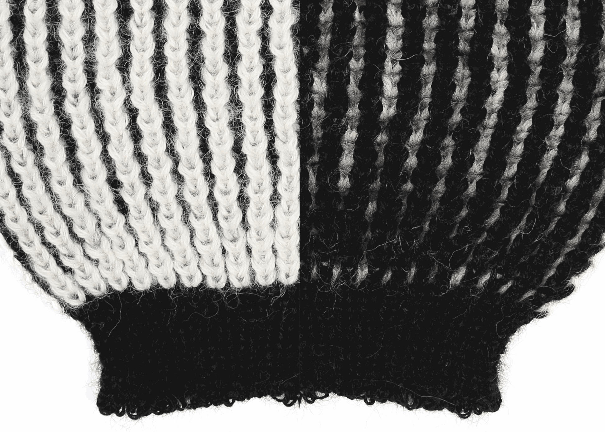 Sleeve detail of a white and black ribbed knit 
