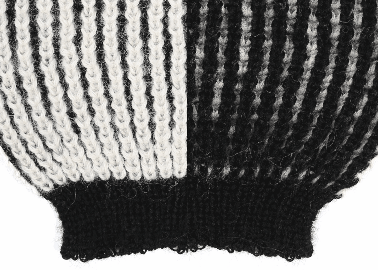 Sleeve detail of a white and black ribbed knit 