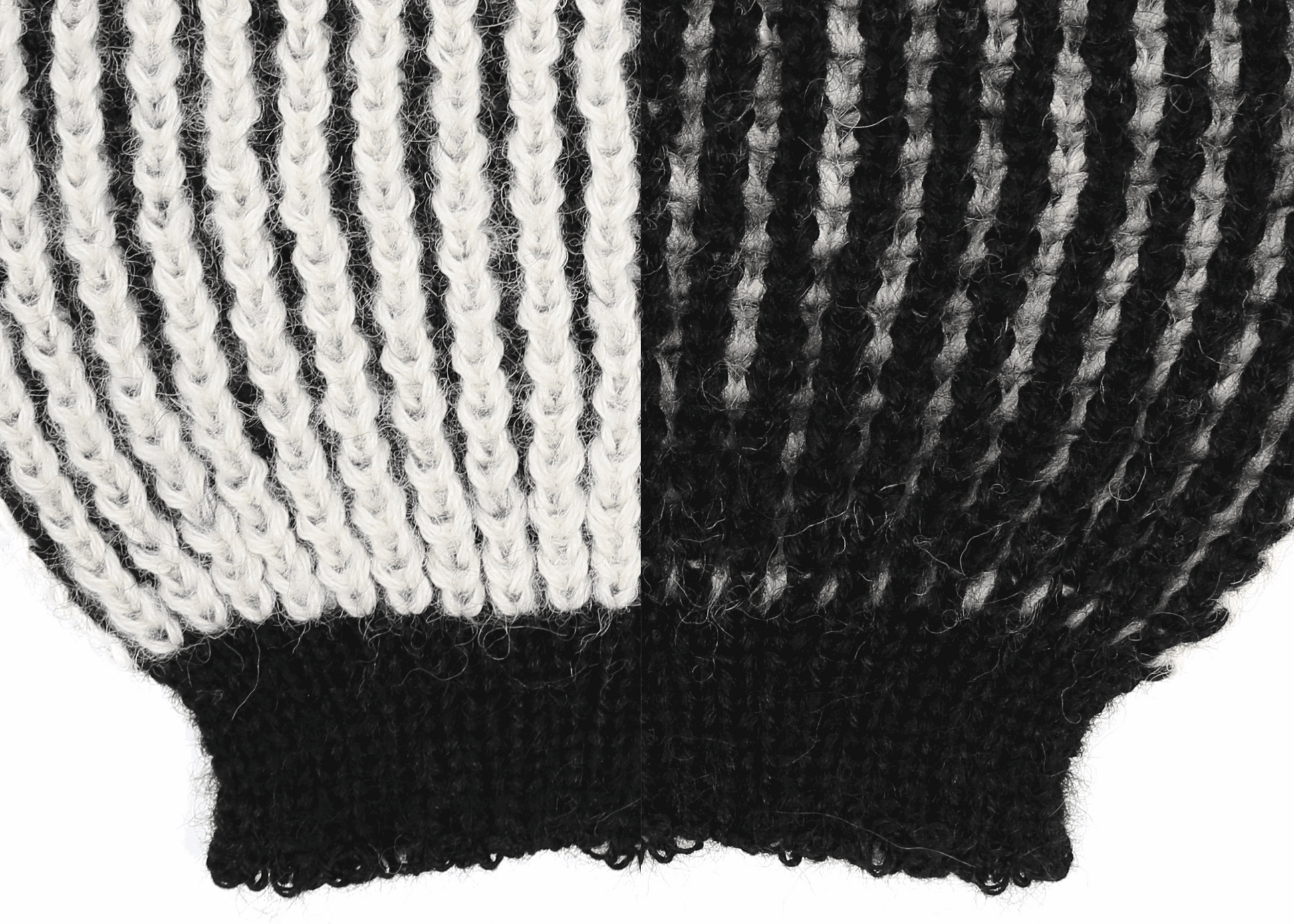 Sleeve detail of a white and black ribbed knit 