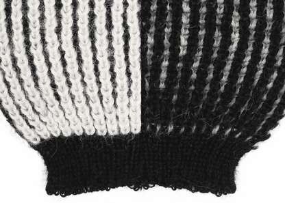 Sleeve detail of a white and black ribbed knit 