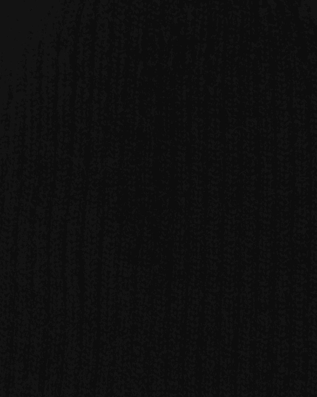 Close-up of the Belacaro kids beanie in black baby alpaca, showing the ribbed knit texture and soft wool fibers.