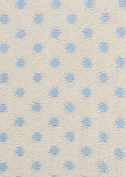 Patterned knit fabric with light blue dots on a beige background