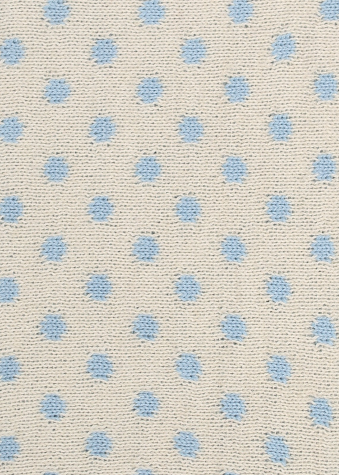 Patterned knit fabric with light blue dots on a beige background