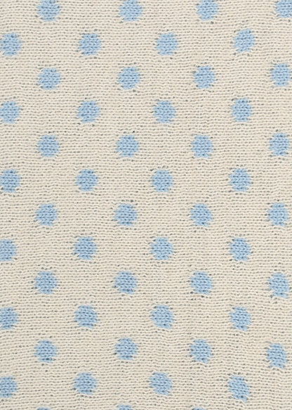 Patterned knit fabric with light blue dots on a beige background