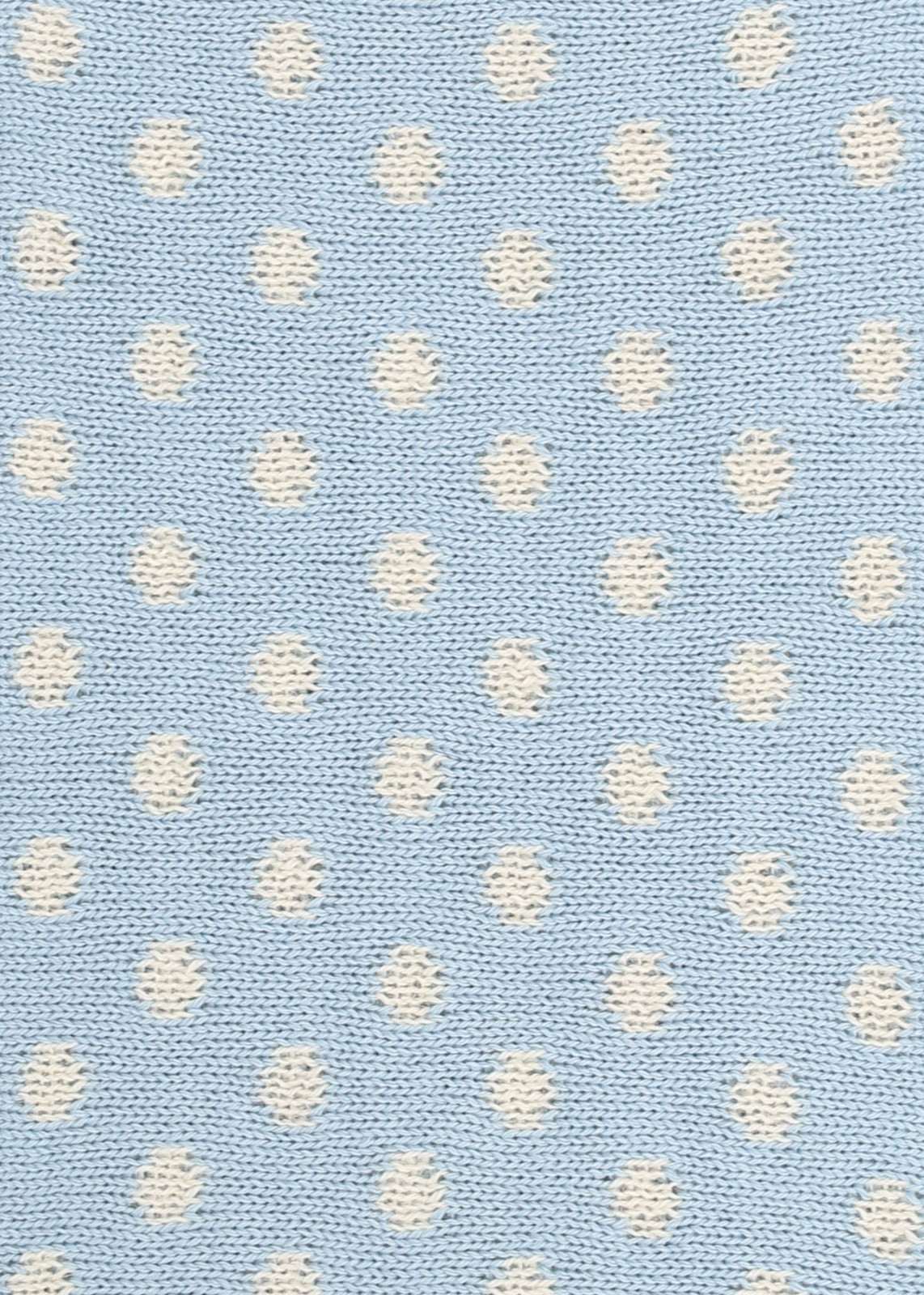 Patterned knit fabric with white dots on a light blue background