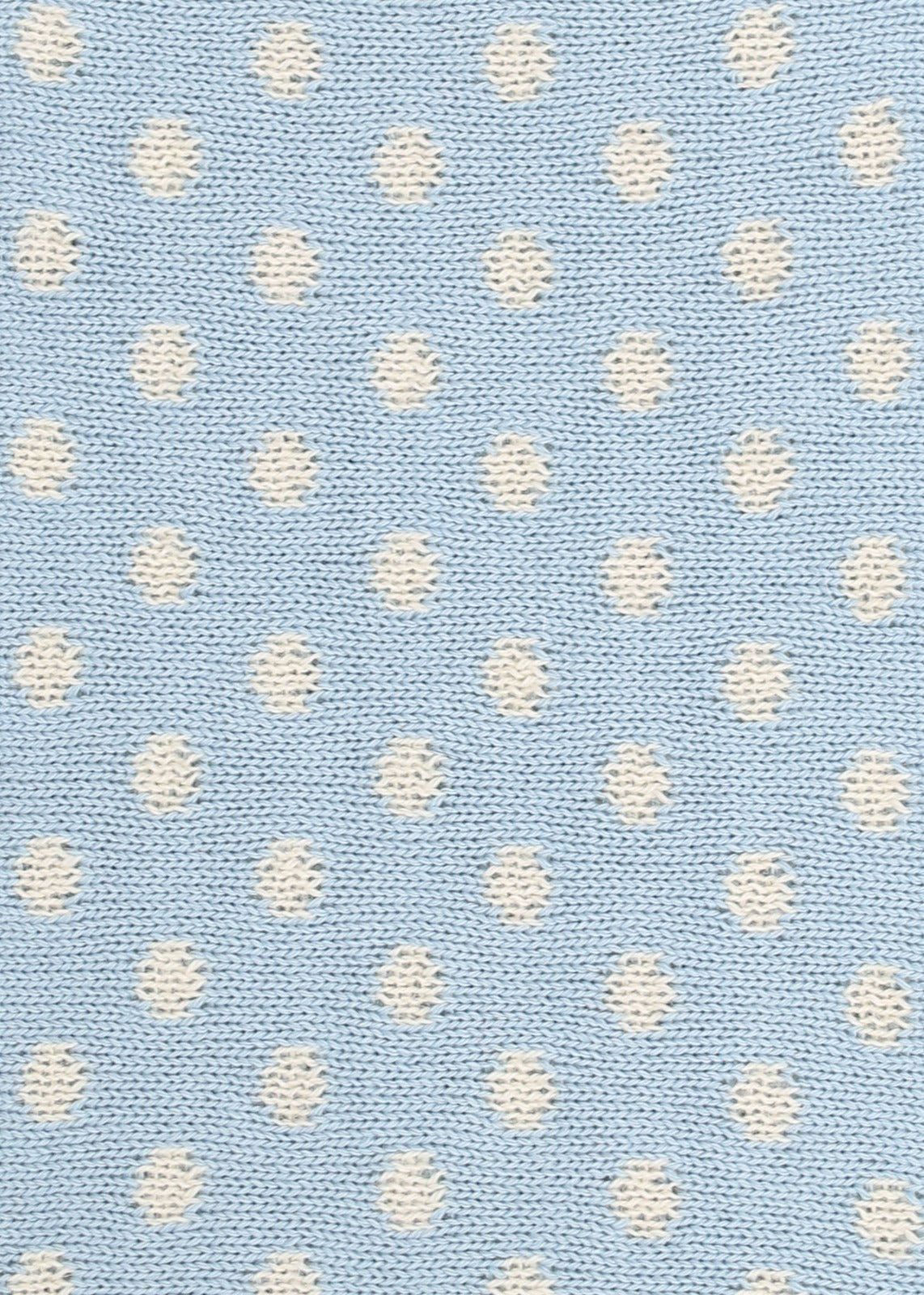 Patterned knit fabric with white dots on a light blue background