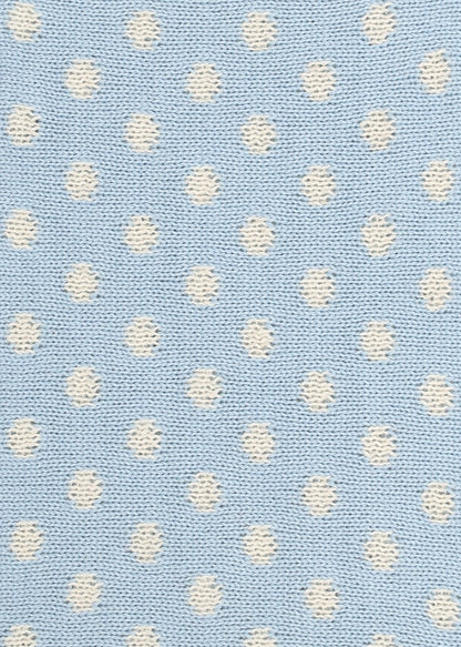 Patterned knit fabric with white dots on a light blue background