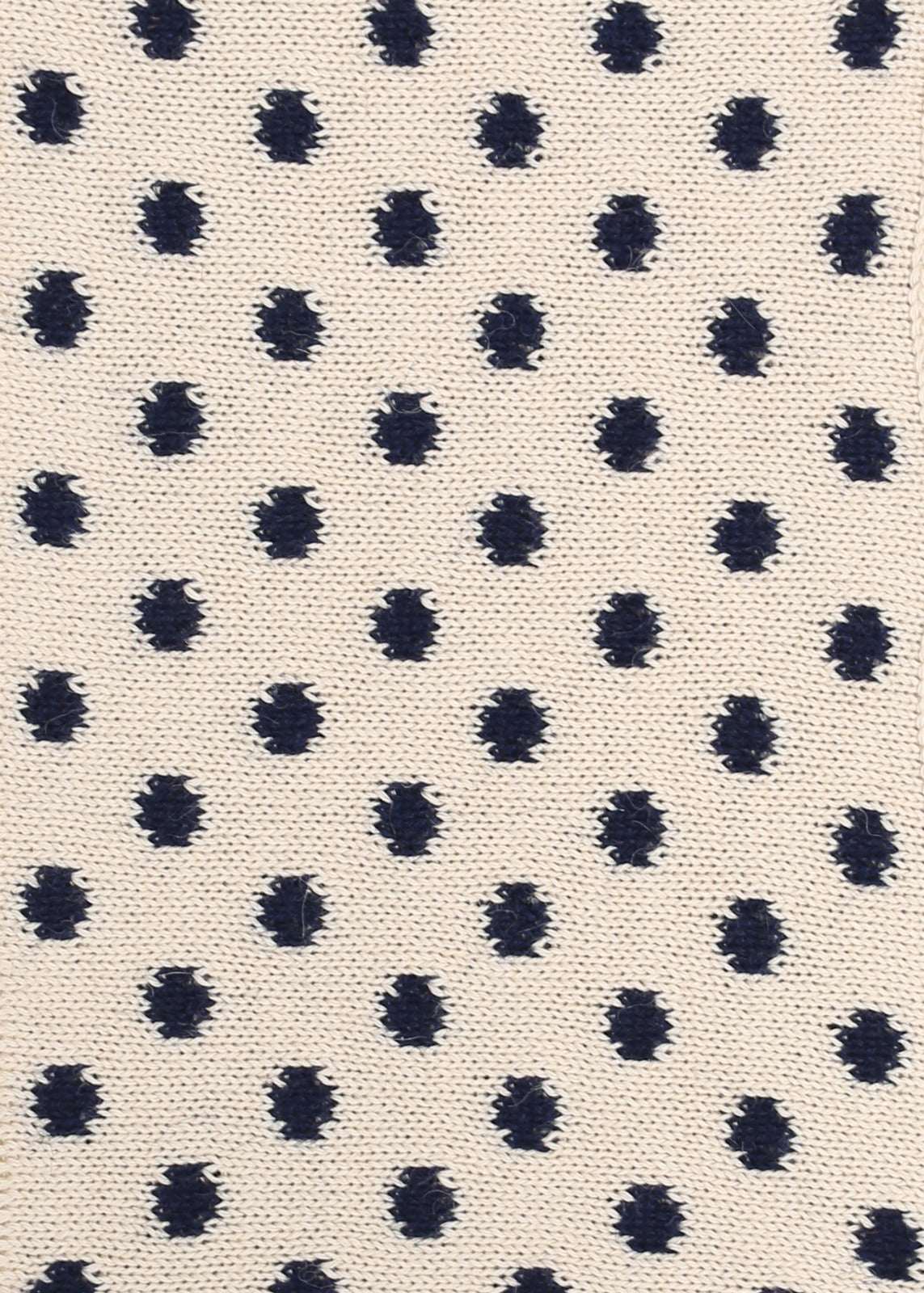 Patterned knit fabric with navy dots on a beige background
