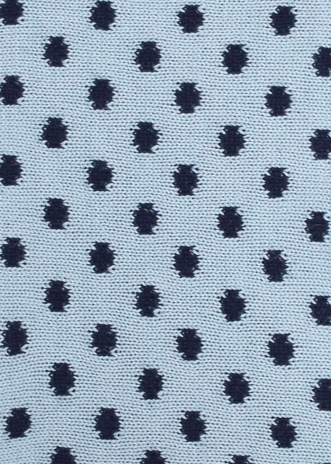 Patterned knit fabric with navy dots on a light blue background
