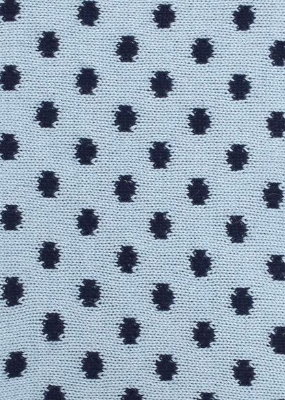 Patterned knit fabric with navy dots on a light blue background