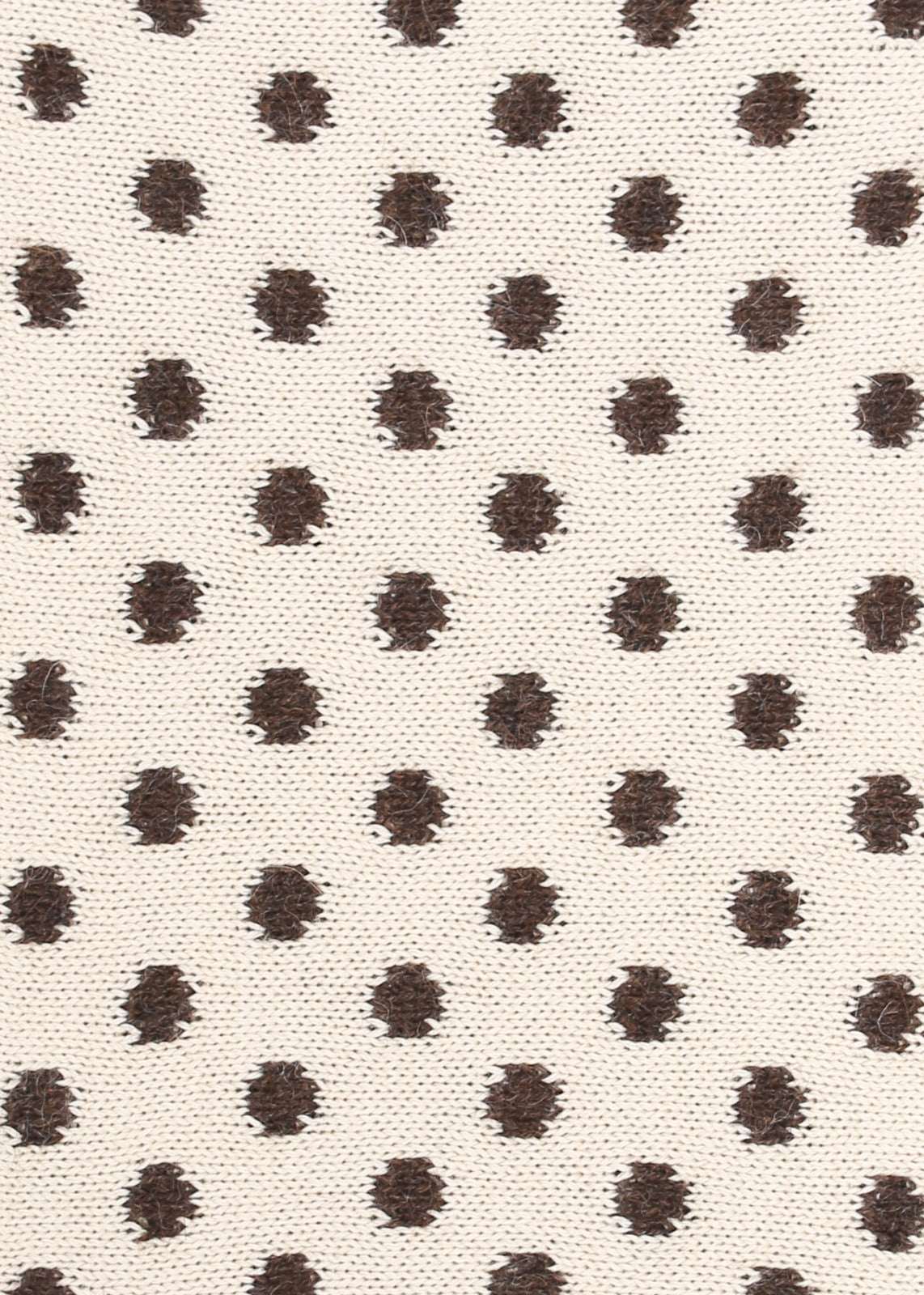 Patterned knit fabric with brown dots on a beige background