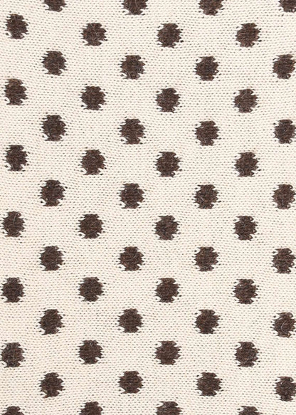 Patterned knit fabric with brown dots on a beige background