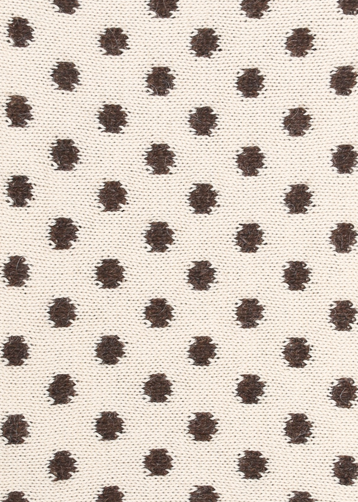 Patterned knit fabric with brown dots on a beige background