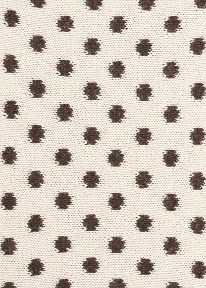Patterned knit fabric with brown dots on a beige background