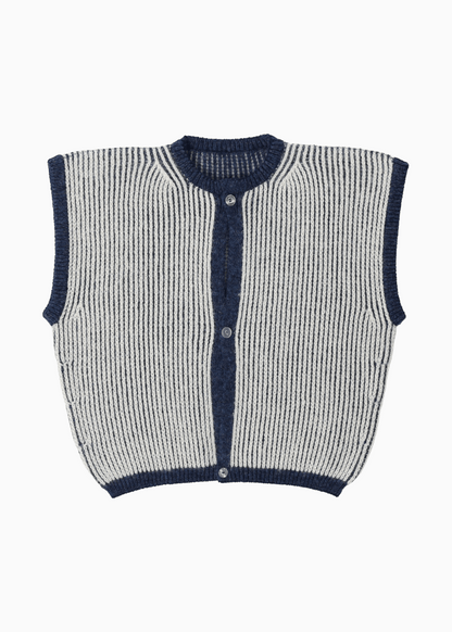 A white and navy reversible vest with heavy english rib knits on a white background