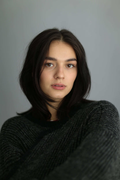 Portrait of a model wearing a grey and black ribbed cardigan