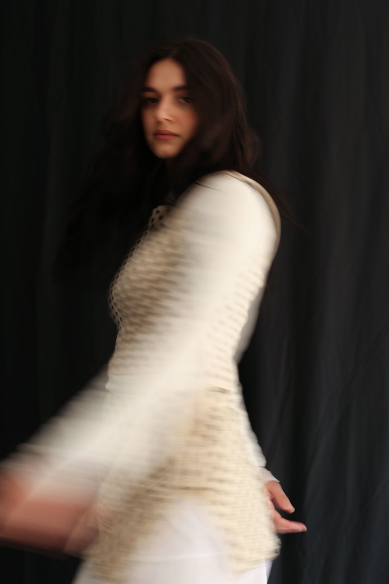Woman wearing a polka dot top against a black background