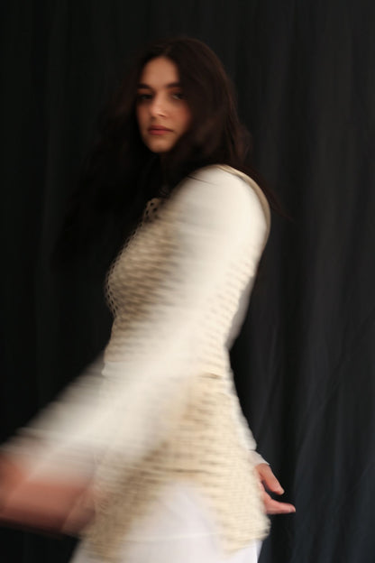 Woman wearing a polka dot top against a black background