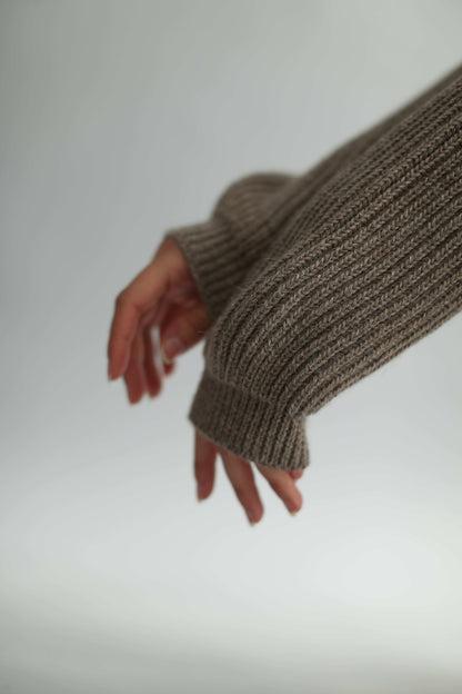 Hands of a model wearing ribbed brown knit